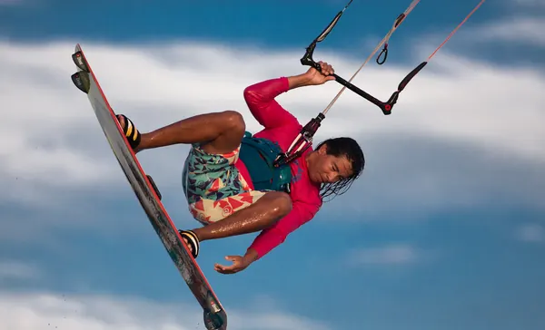 Kitesurfer in a big jump against the clouds in Aruba