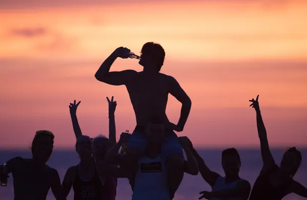 Friends celebrating on the beach at sunset